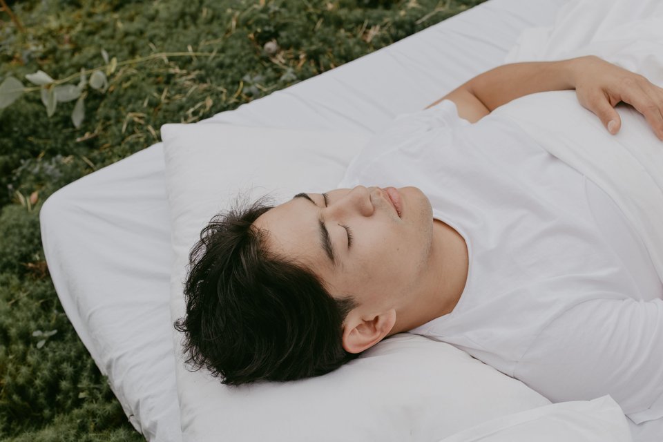 คนนอนบนเตียงหลับตาและหายใจอย่างสงบก่อนนอน