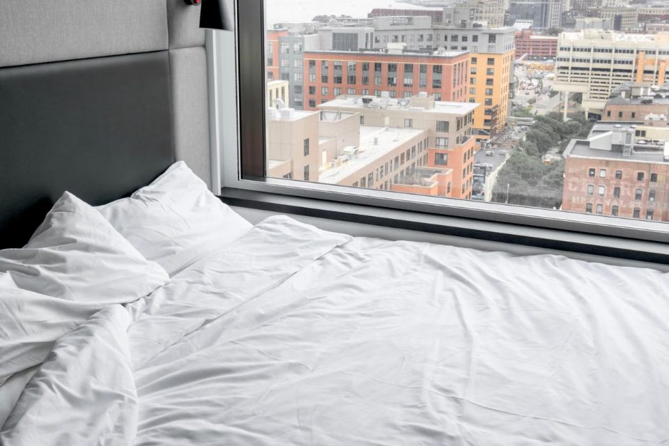 A hotel room bed with a city view — the first night effect on sleep
