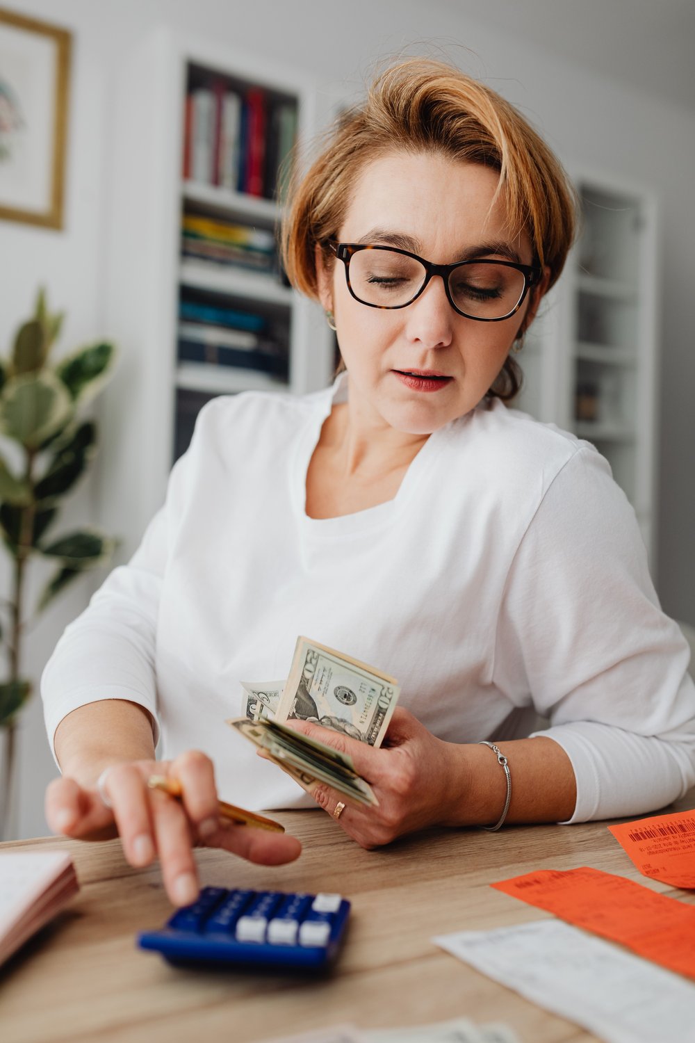 Persona esamina con calma il bilancio a tavola — stress finanziario e salute