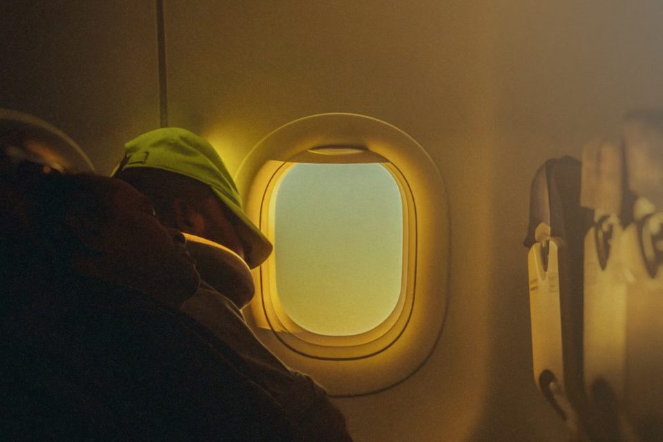 Passeggero addormentato sul sedile accanto al finestrino: come dormire in aereo