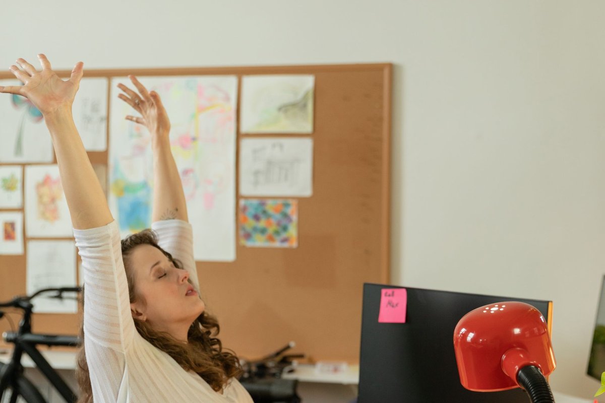 Femme à son bureau inclinant la tête sur le côté — étirement nuque