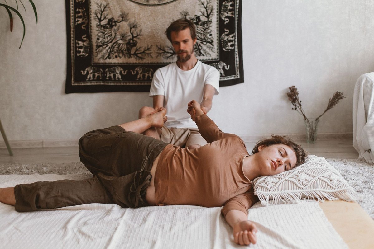 Thaise masseur rekt de rug van een cliënt op een mat