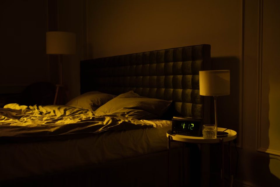 Camera oscurata con la luce soffusa di una lampada notturna: silenzio e rumore bianco per dormire